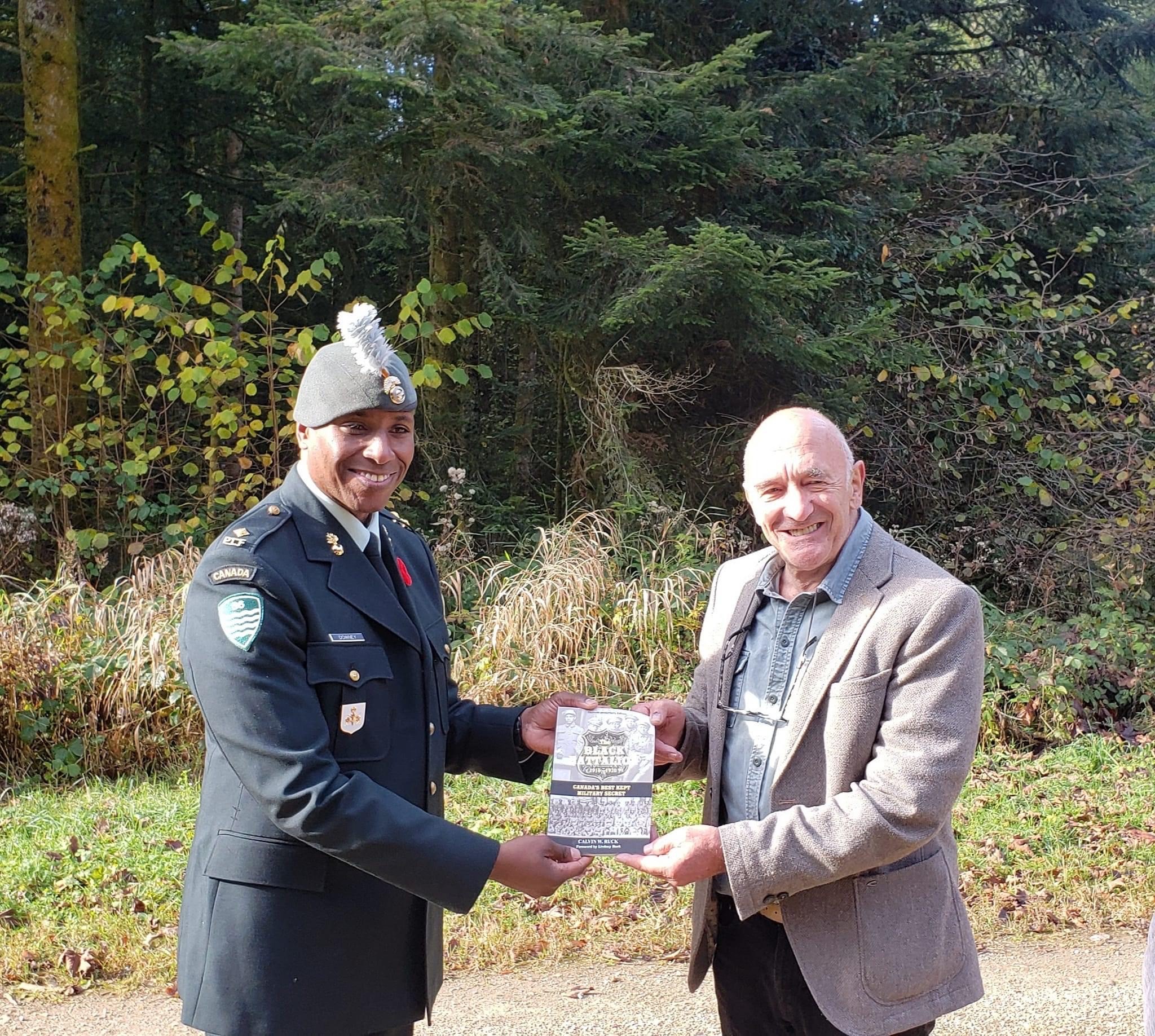 2Lt Downey presenting a book on the No.2 Construction Battalion to a local historian.