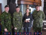 Ashley McPherson,the daughter of MWO J.W. McPherson (Edmonton), receiving the bursary cheque from WO C. Kavanagh, MWO J. McPherson and MWO M. Dumont.