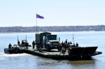 35 CER members transport an MSVS vehicle on a floating bridge set up on the St. Lawrence River. Photo // Les membres du 35e RGC transportent un véhicule MSVS sur un pont flottant monté sur le Fleuve St-Laurent. Photo : Lt Isabelle Provost