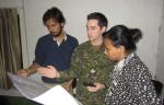 MCpl Denis Carièrre, a DART geomatics technician explains mapping details to Prabhas Pokharel and Megha Shrestha, both volunteers for Kathmandu Living Labs. // Le CplC Denis Carierre, un technicien en géomatique de l’EICC explique les détails du processus de cartographie à Prabhas Pokharel et Megha Shrestha, deux bénévoles des laboratoires vivants de Kathmandu.