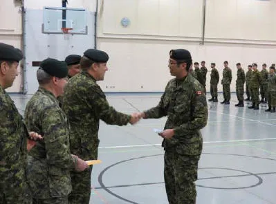 Cpl Ryan Bae, a member of 32 CER (Toronto), receiving the bursary cheque from Col D. Hobbs, Comd 32 Bde and LCol M. Clarry, CO 32 CER.