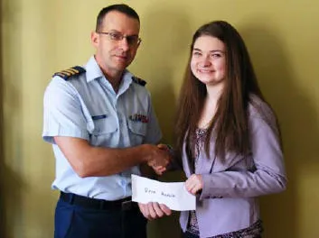 Erin Aucoin, daughter of LCol R.J. Aucoin (Ottawa), receiving the bursary cheque from her father.