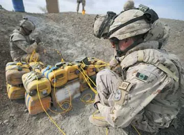 Canadian combat engineers rig improvised explosive devices with C-4 and a detonation cord to dispose of them.