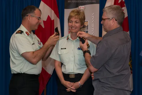 Brigadier-General Jennie Carignan (center) is promoted by Major-General Eric Tremblay (left) and her husband Eric Lefrançois at a ceremony held at Canadian Forces College in Toronto, ON./La brigadier-général Jennie Carignan (au centre) est promue par le major-général Éric Tremblay (à gauche). Son conjoint Éric Lefrançois figure également sur la photo, prise lors d’une cérémonie tenue au Collège des Forces canadiennes à Toronto (Ontario).