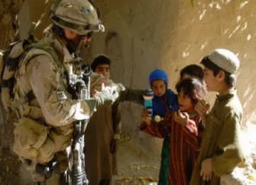 Canadian soldier giving Izzy Dolls to Afghan chidlren