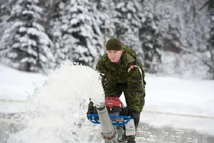 Spr Maxime Thibault floods the ice to increase the load-bearing capacity of the bridge and allow vehicles to cross. // Le Sapeur Maxime Thibault arrose la glace pour augmenter la capacité portante du pont et permettre la traverse de véhicules.  (Photo: Lt Isabelle Provost)