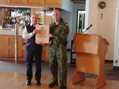 Dennis Dwyer receives an engraved plaque from the Edmonton Chapter of the CMEA