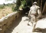 A sapper conducts a check for mines and IEDs with a mine detector.