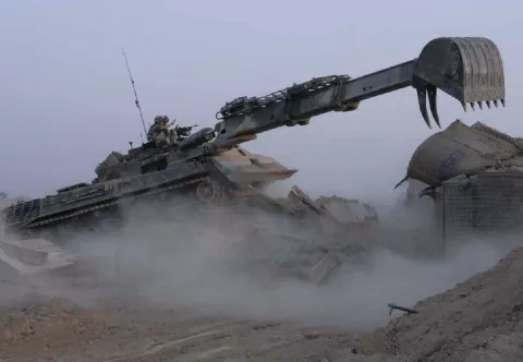The multi-purpose Badger using its arm to clear debris. It is also equipped with a blade for earth works and clearance.