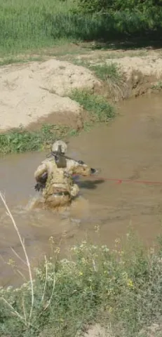 Sapper crossing a wadi to clear the other side before the convoy drives through.